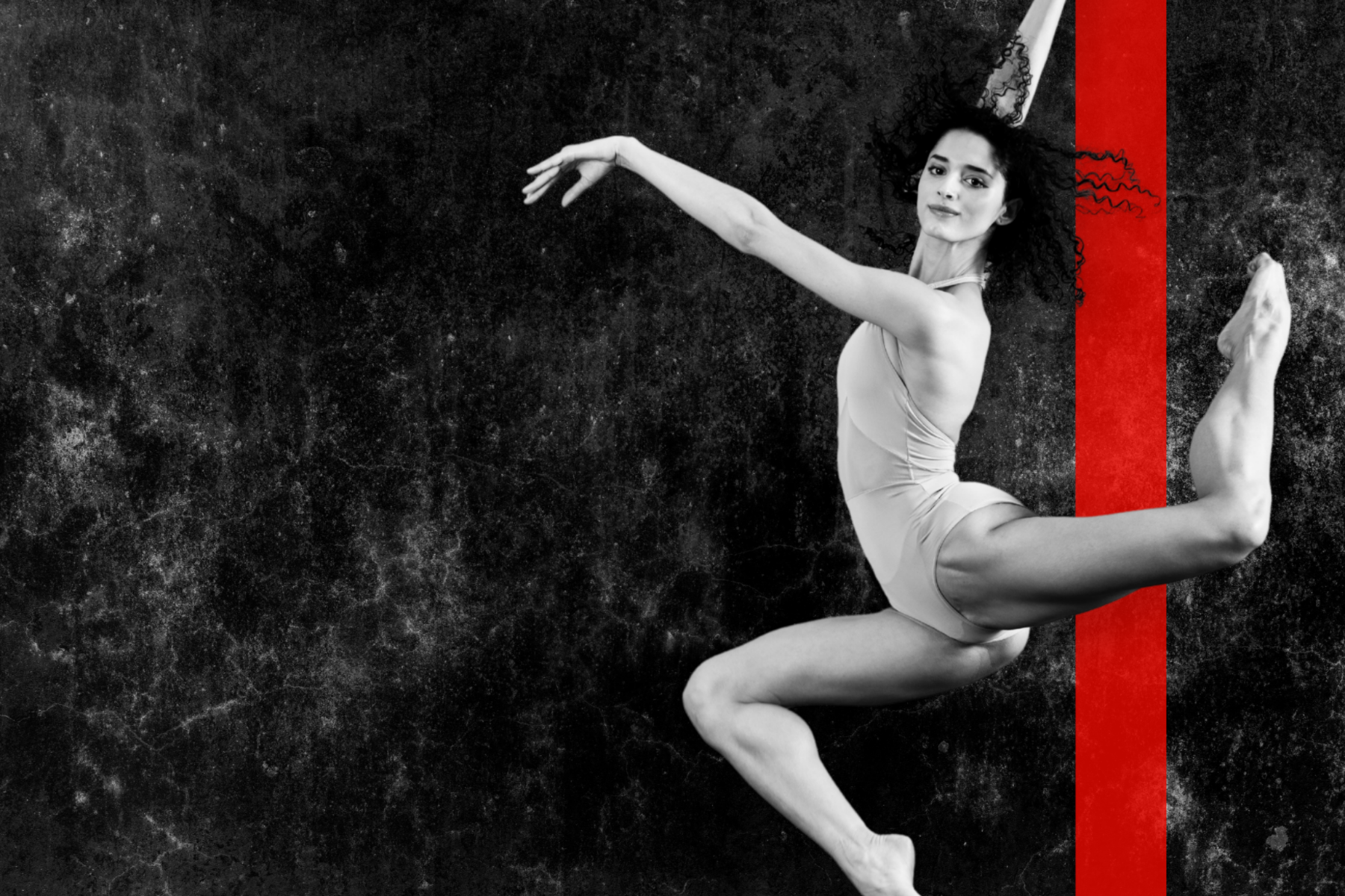 black and white female dancer posed mid-air with vertical red stripe in the background