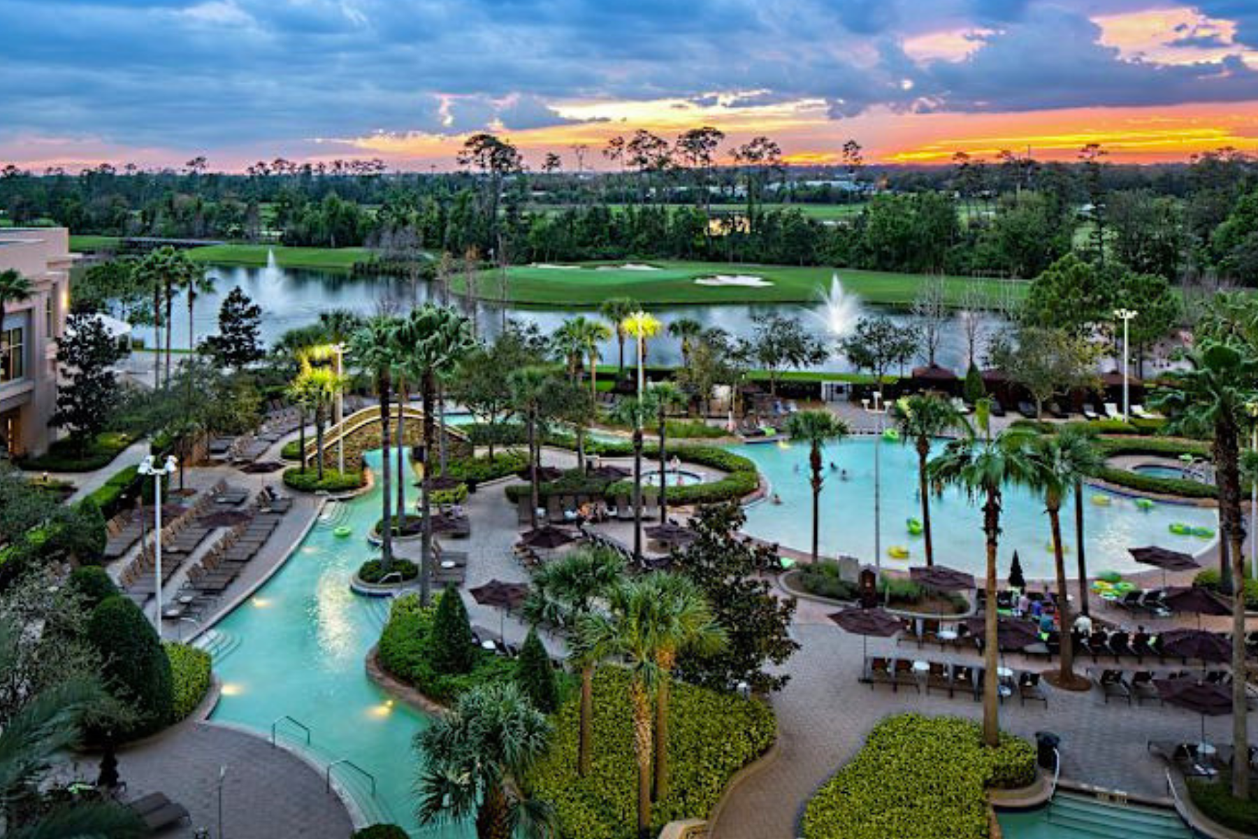 Resort during sunset from above angle with view of pool and golf course