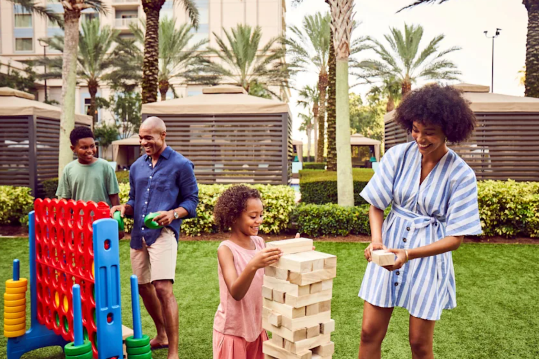 Happy family playing giant jenga and connect four