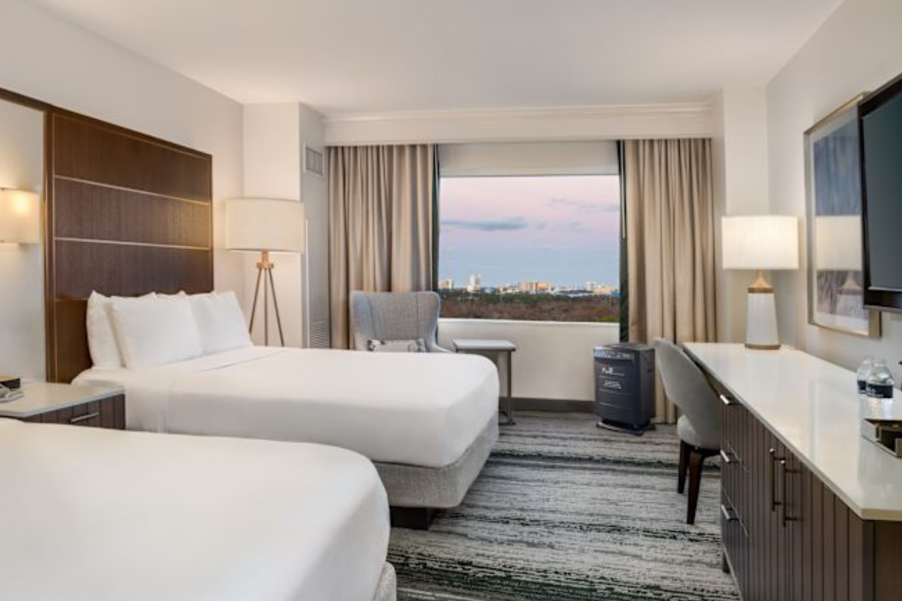 Hotel room with two double beds and view of city skyline