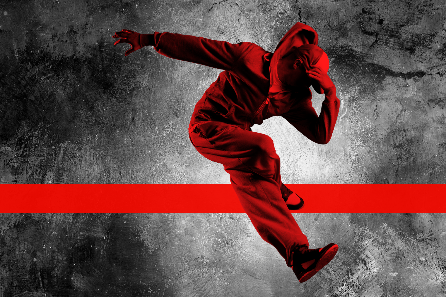 Male dancer posed mid-air with red color overlay and vertical red stripe in the background